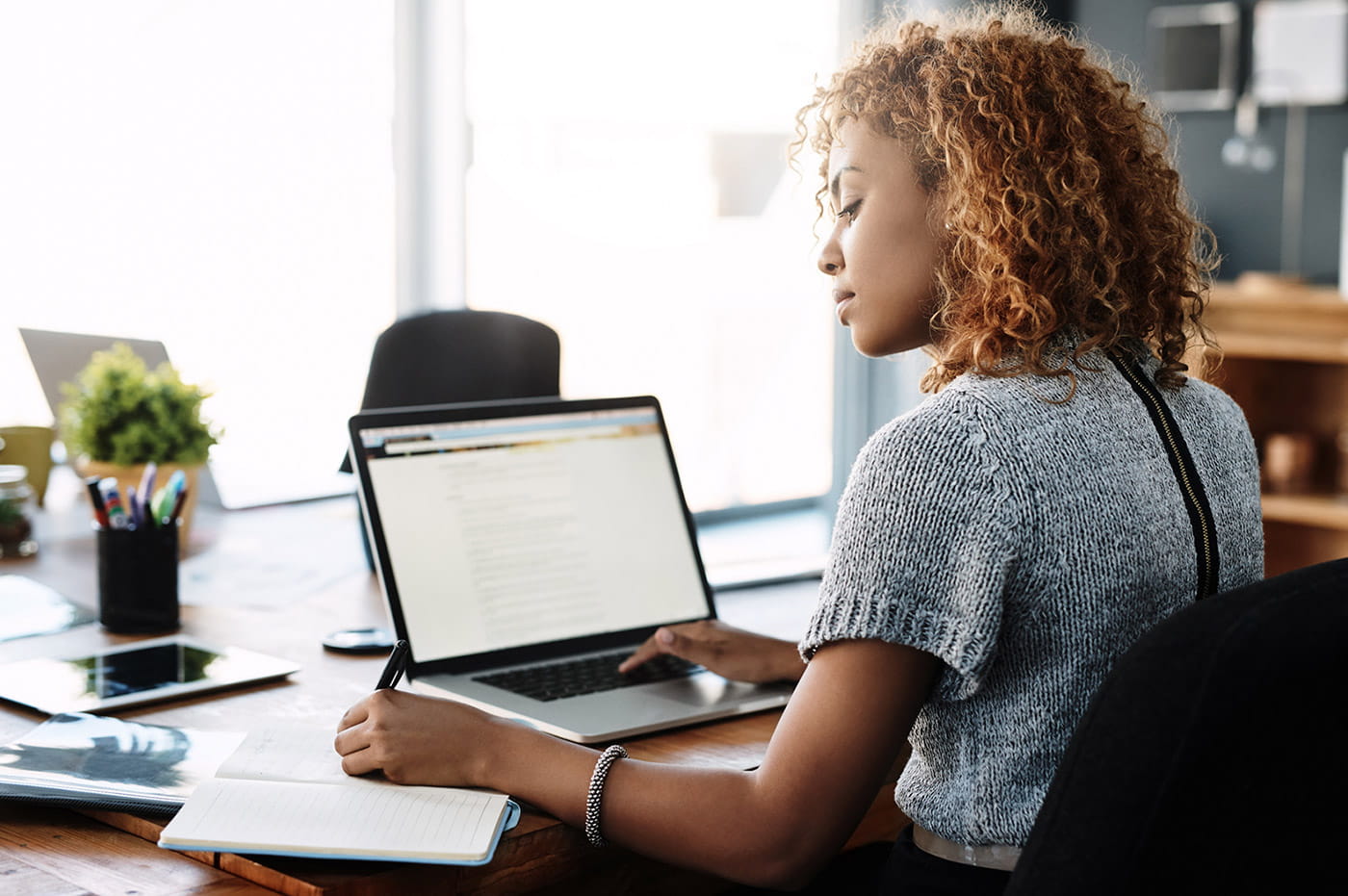 A woman typing on a laptop device